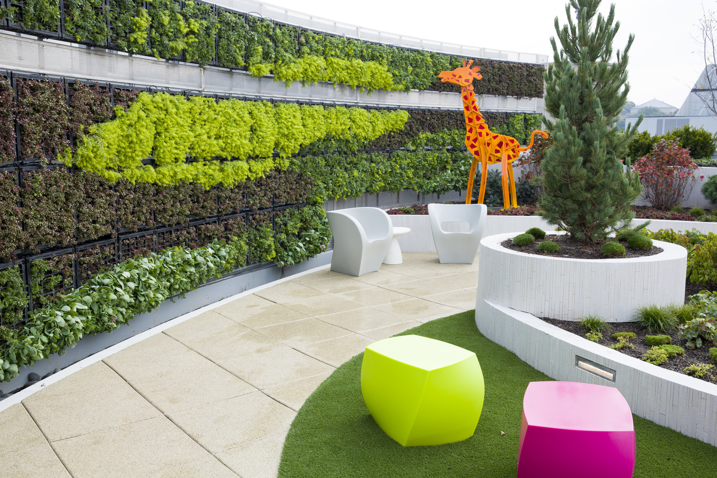a rooftop garden with bright colors and a large decorative giraffe 