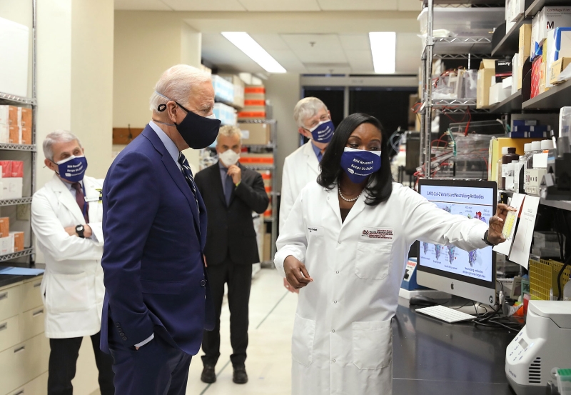 U.S. President Joe Biden and Former U.S. Chief Medical Advisor to the president and three other people wear masks as a researcher shares new COVID vaccine development updates..