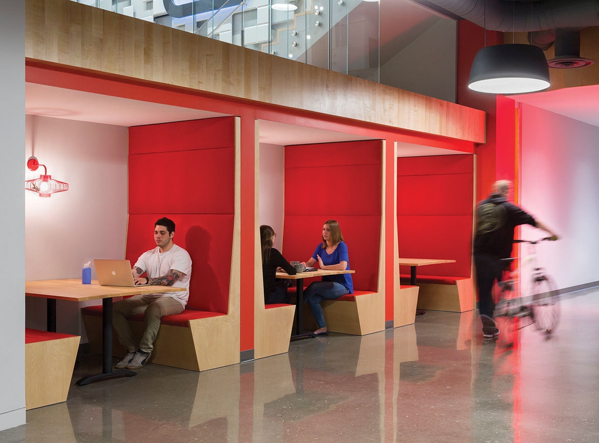 Small booth meeting pods with red fabric and wood accents. 